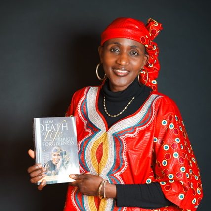 Evelyne Mukasonga holding the book